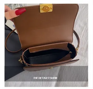 Detail view of the brown leather bag interior with black lining and a zippered pocket