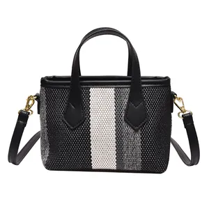 Bolso cubo de lona a rayas con correas de cuero negro y herrajes dorados para mujer
