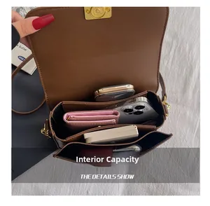 Macro view of interior compartments and golden swivel lock of the brown leather bag