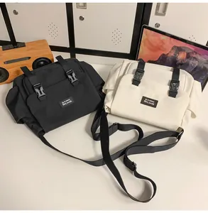 Gros plan de sacs messagers en nylon noir et beige avec boucles et sangles réglables