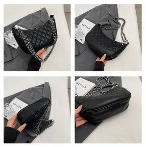 Detail view of black quilted hobo bag with silver chain strap and half-moon silhouette