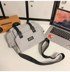 Gros plan sur le sac messager utilitaire gris avec boucles et nylon résistant à l'eau