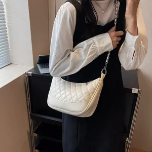 Chic white quilted crescent bag featuring an elegant metal chain and leather strap