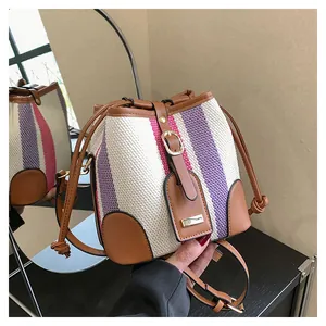 Detail view of the drawstring closure and striped canvas texture of this bucket bag