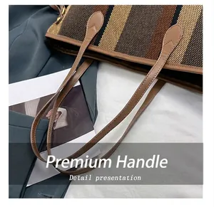 Close-up of durable leather handles and fine stitching on a striped canvas tote bag