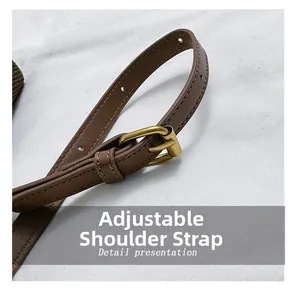 Detailed close-up of adjustable brown leather shoulder strap with vintage gold metal buckle