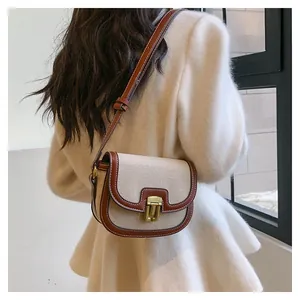 Detail of vintage canvas saddle bag with brown leather trim and white contrast stitching