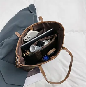 Detail presentation of spacious interior capacity for large brown tote bag with daily items