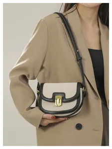 Detail of vintage saddle bag featuring beige canvas, black leather trim and white stitching