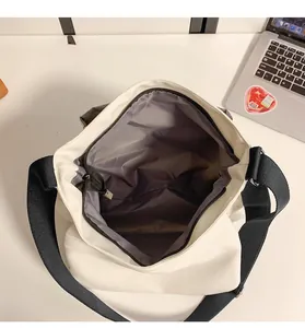 Détail de l'intérieur spacieux d'un cabas en nylon blanc avec doublure grise et fermeture