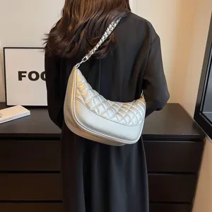 Silver quilted half-moon hobo bag with metallic finish and woven chain strap on shoulder