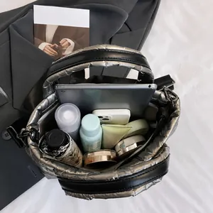 Spacious metallic quilted bag showing interior capacity for tablet, umbrella, and makeup