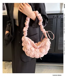 Detalle de bolso nube rosa claro con textura acolchada y asa con pliegues
