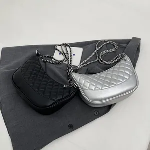 Detail of half-moon shoulder bags in black and silver with quilted chain straps