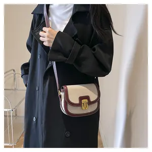 Close-up of a retro canvas saddle bag with burgundy leather trim and gold metal clasp