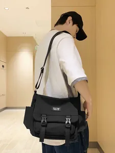 Sacoche unisexe noire au style fonctionnel avec poches multiples et boucle de fermeture