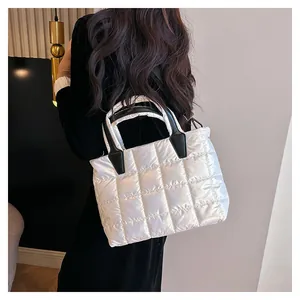 Dettaglio della borsa shopper imbottita bianca con manici neri e anelli a D in metallo