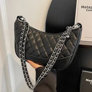 Women's black quilted half-moon shoulder bag with silver chain strap and metal ball charm