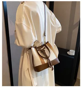 Detail of color-block bucket bag showing drawstring closure and brown leather texture