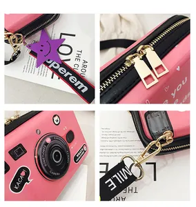 Detail of pink camera-shaped crossbody bag with glossy finish and durable shoulder strap