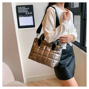 Elegante borsa tote trapuntata metallizzata con tracolla larga indossata da modella