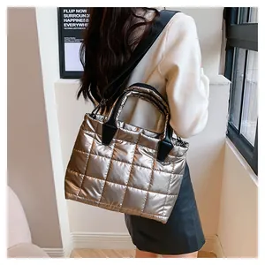 Borsa tote trapuntata argento metallizzato moderna con vista laterale e tracolla nera larga