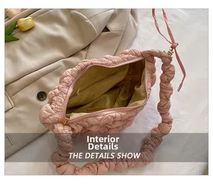 Vista interna del bolso acolchado rosa que muestra el bolsillo con cremallera y forro