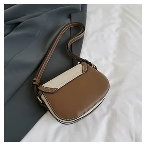Detail of vintage saddle bag with brown leather and beige canvas on grey suit