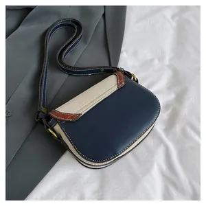 Macro detail of retro contrast saddle bag showing texture, stitching and bronze buckle