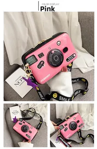 Detailed close-up of a pink camera-shaped crossbody bag with a glossy finish and smile strap