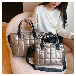 Dettaglio di borse trapuntate dorate in due misure con tracolle larghe in nylon nero