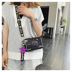 Detail of camera-shaped crossbody bag with a wide smile-pattern strap on a model