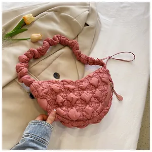 Detalle de bolso nube rosa con textura acolchada y correa fruncida para el hombro