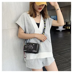 Detail of creative retro camera-shaped crossbody bag with a smile print shoulder strap