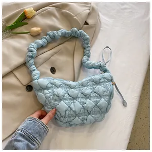 Detalle del bolso de nube acolchado azul claro y diseño de correa de hombro fruncida