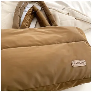 Gros plan sur le sac fourre-tout matelassé marron avec un patch de mode en cuir