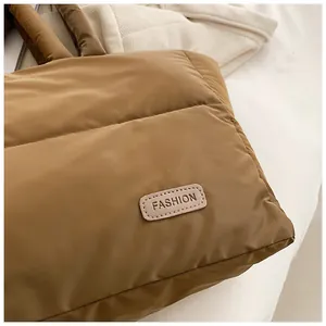 Gros plan sur un sac cabas matelassé caramel brillant avec une étiquette logo mode