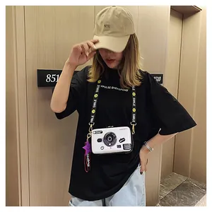 Model showcasing a vintage camera shaped crossbody bag with a yellow smile patterned strap