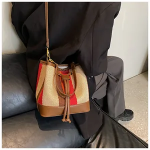 Detail of vintage striped bucket bag showing canvas texture and brown leather drawstring