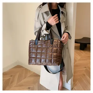 Dettaglio della borsa shopper trapuntata marrone scuro con finitura satinata e manici
