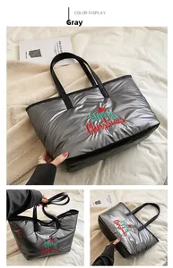 Détail d'un sac cabas matelassé gris argenté avec broderie de Noël et poignées noires