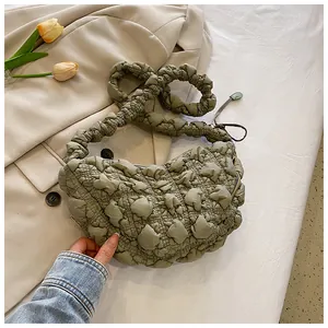 Detalle de bolso nube verde claro con textura fruncida y asa acolchada suave