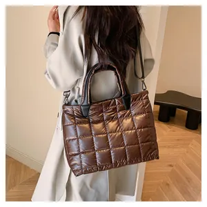 Borsa trapuntata marrone scuro indossata da una modella per un look di tendenza attuale