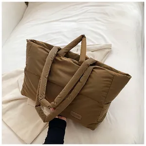 Détail du grand sac cabas matelassé marron café avec écusson mode sur le devant