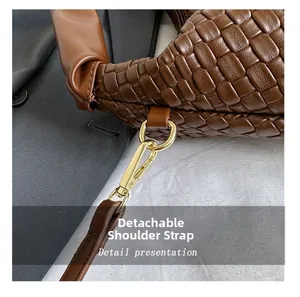Détail du sac cabas en cuir tressé à la main avec bandoulière amovible et fermoir doré