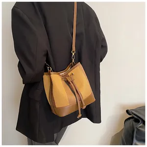 Detail of vintage striped bucket bag with drawstring closure and brown leather straps