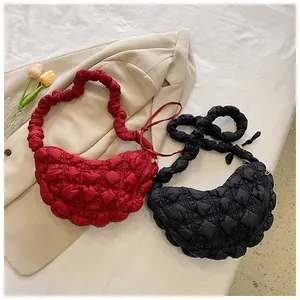 Detalle de bolsos acolchados en rojo y negro con correas de diseño fruncido