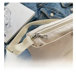 Close-up of smooth silver zipper and durable canvas texture on a beige shoulder bag