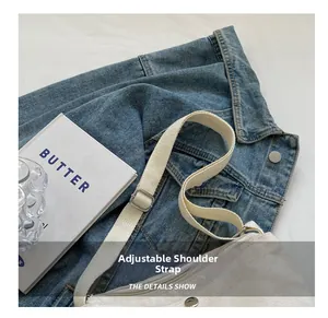 Detail showing the adjustable fabric strap and silver metal buckle on the off-white canvas bag