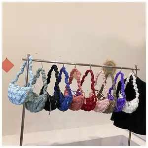 Colección de bolsos acolchados estilo nube en diez colores colgados en un expositor